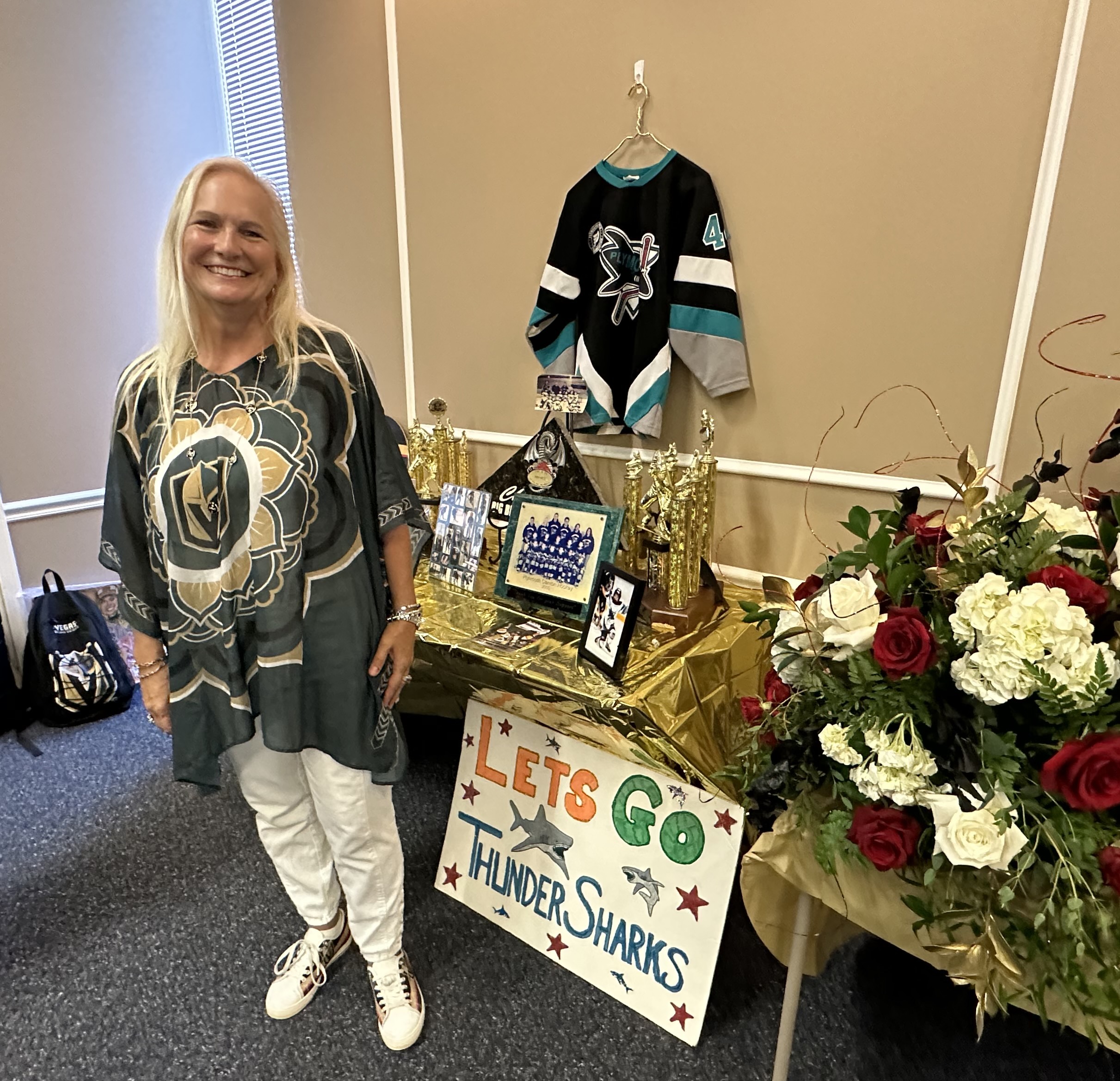 Lisa Cotter poses with some of her son's youth hockey memorabilia