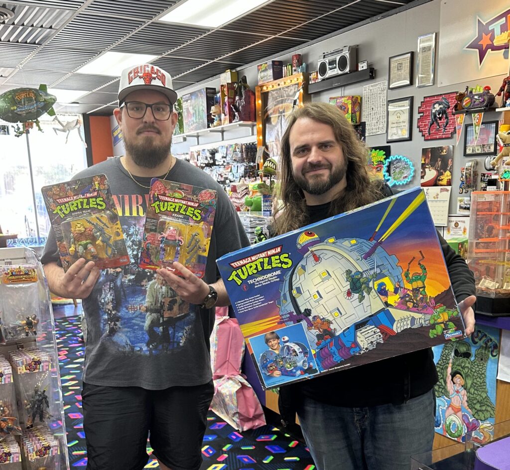 Joe Dalessandro and Keith Libra hold a couple valuable toys that are on display at Timeblaster Toys.